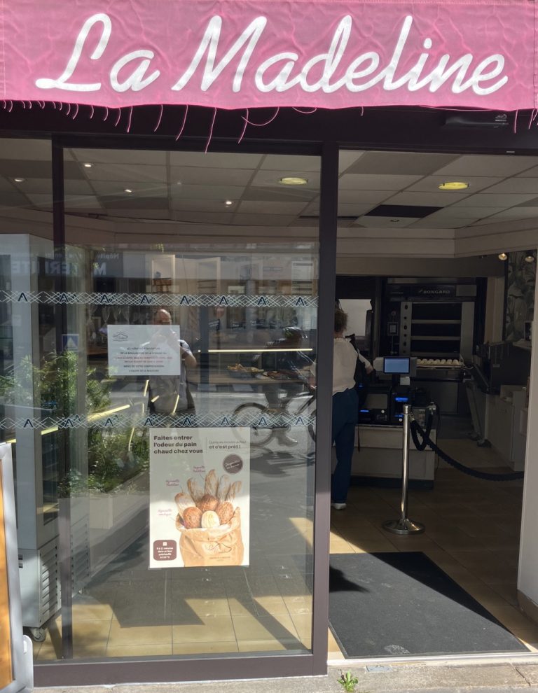 Affiche pain précuit installée dans la vitrine de la boulangerie La Madeline